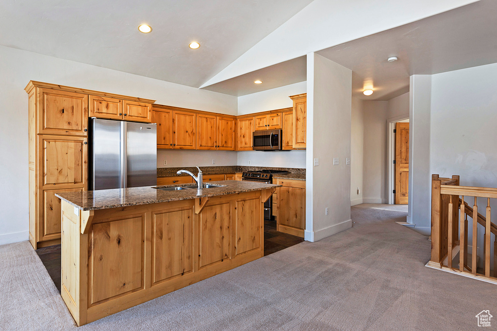 Kitchen featuring stainless steel appliances, dark carpet, recessed lighting, lofted ceiling, and a kitchen island with sink