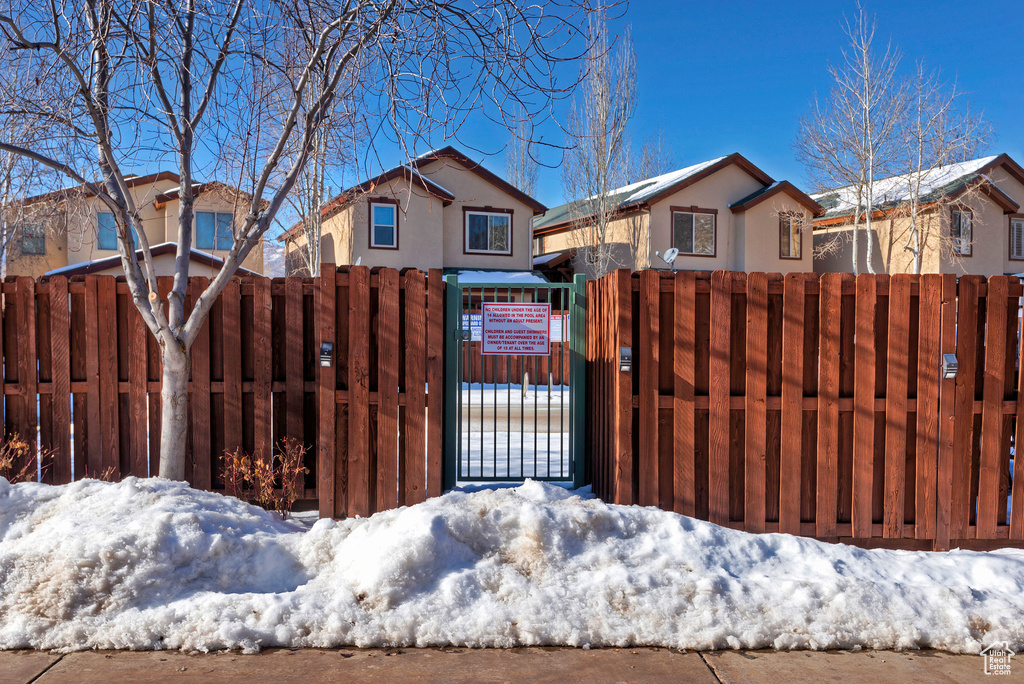 View of front of property with stucco siding, a gate, and a fenced front yard