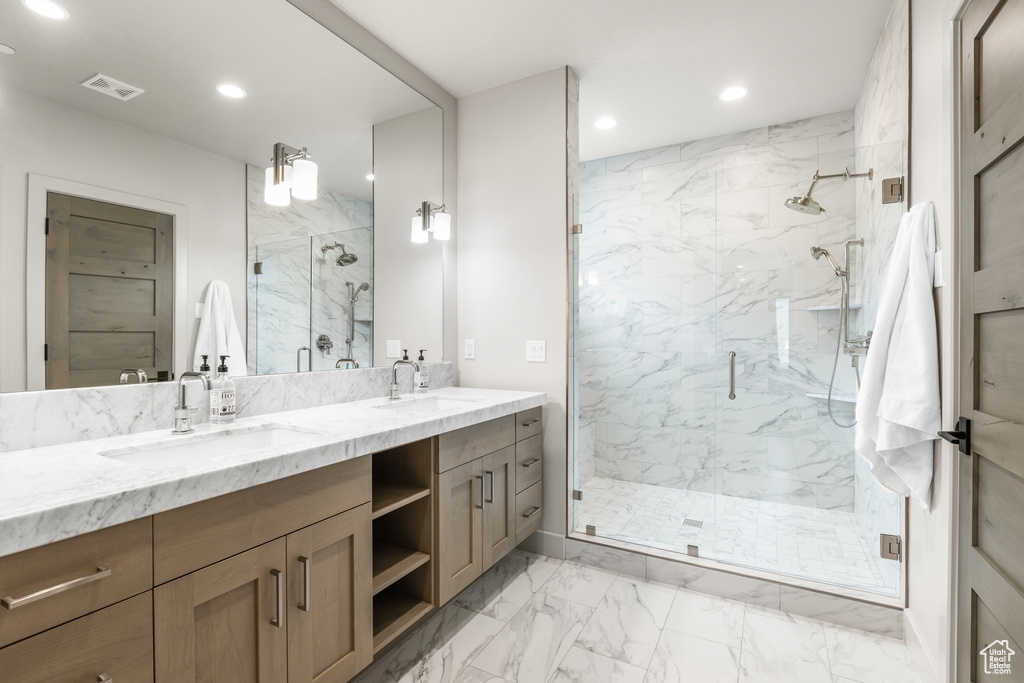 Full bath featuring marble finish floors, recessed lighting, double vanity, and a marble finish shower