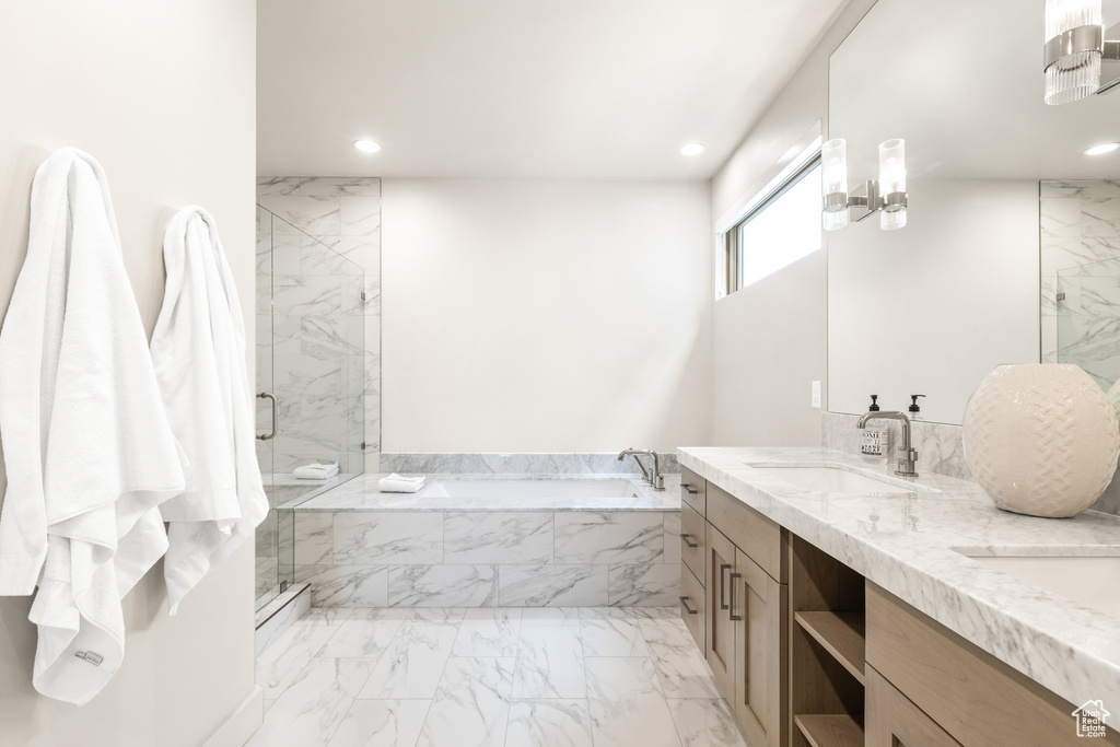 Bathroom featuring a bath, marble finish flooring, recessed lighting, a marble finish shower, and double vanity