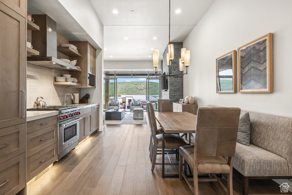 Dining area with light wood finished floors and recessed lighting