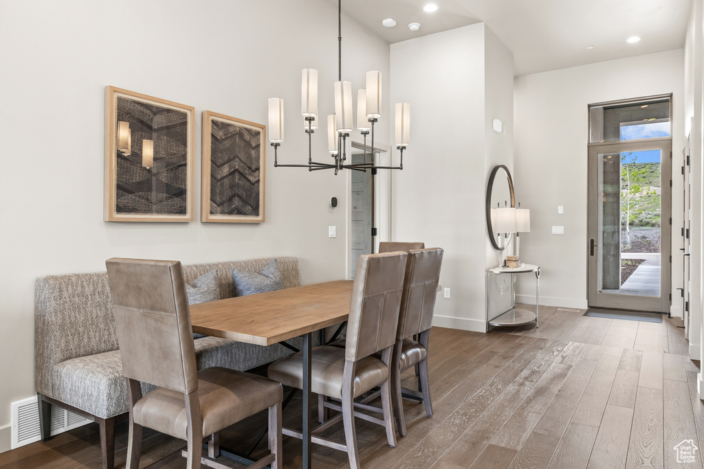 Dining area featuring a chandelier, wood finished floors, and recessed lighting