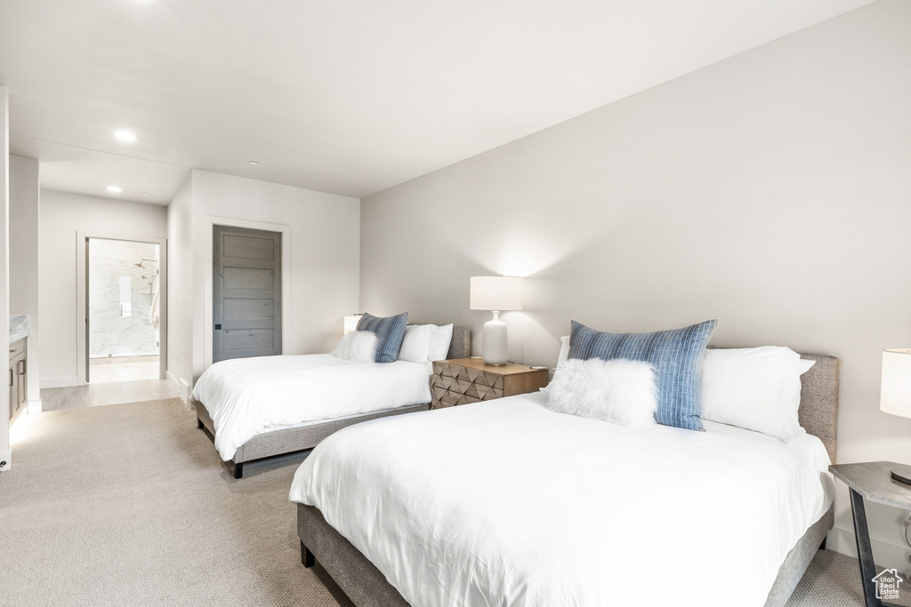 Bedroom featuring light colored carpet, recessed lighting, and ensuite bath