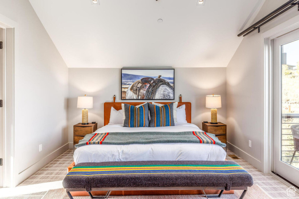 Bedroom with lofted ceiling, carpet flooring, and access to exterior