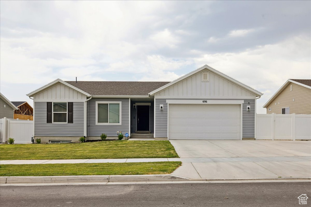 Single story home with board and batten siding, concrete driveway, a garage, and roof with shingles