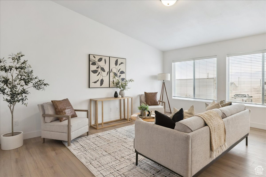 Living room with vaulted ceiling and light wood finished floors