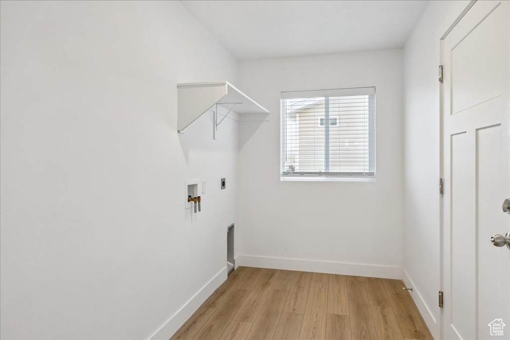 Washroom with light wood-style flooring, electric dryer hookup, and hookup for a washing machine