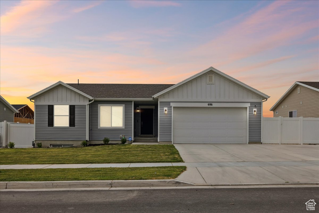 Single story home featuring board and batten siding, concrete driveway, an attached garage, and a shingled roof