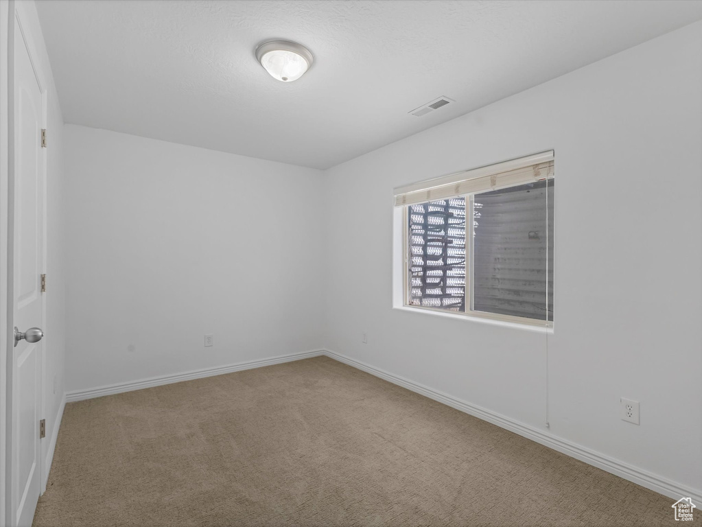 Empty room featuring carpet flooring and baseboards