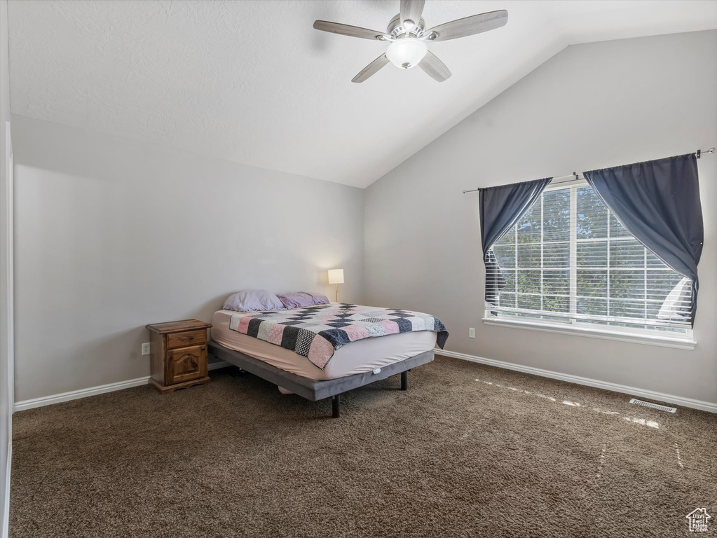 Bedroom with vaulted ceiling, carpet floors, and a ceiling fan