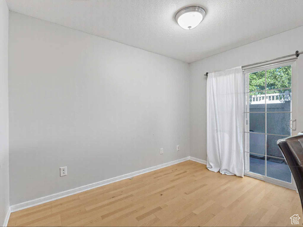Unfurnished room with light wood-style floors and baseboards