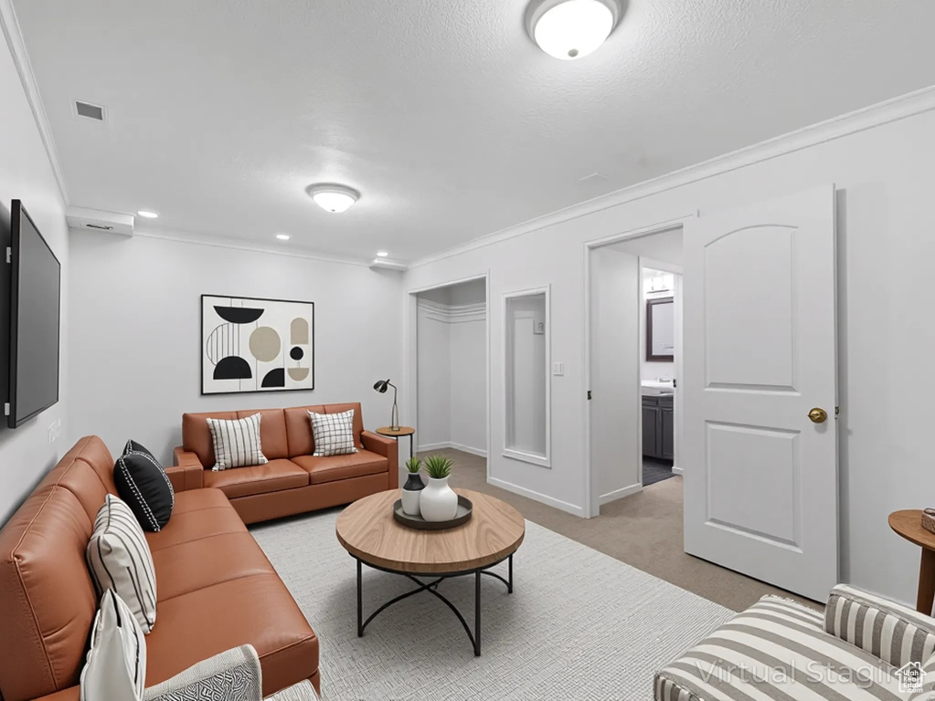 Living room featuring light colored carpet, ornamental molding, and recessed lighting