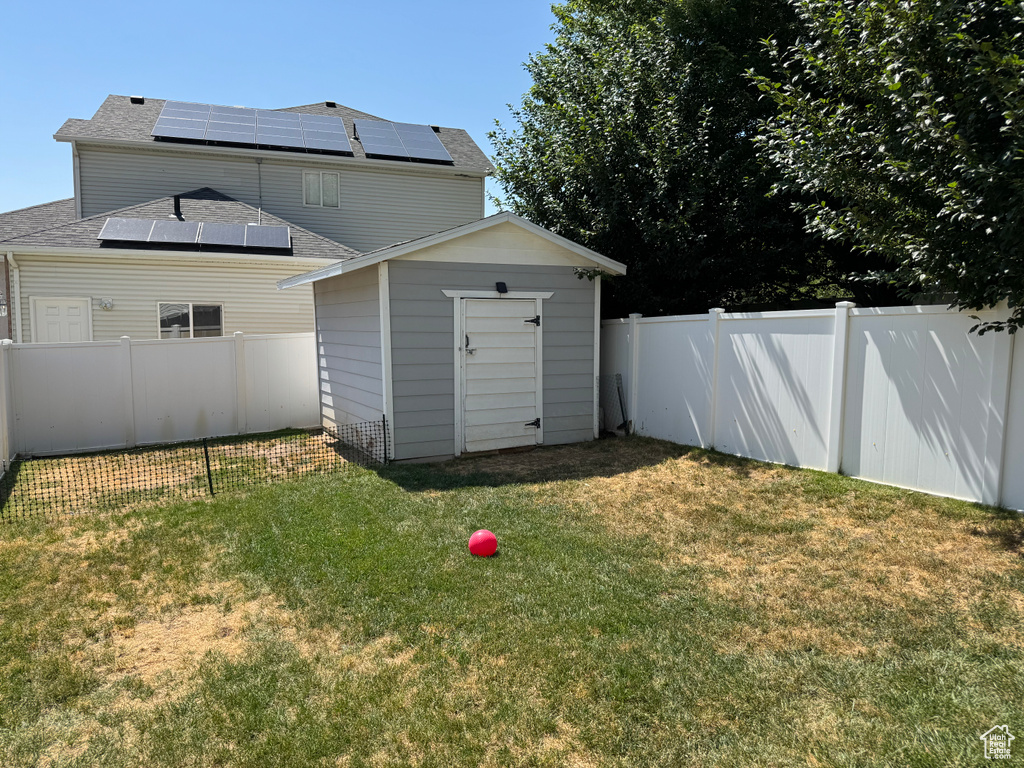 Fenced backyard featuring a storage shed