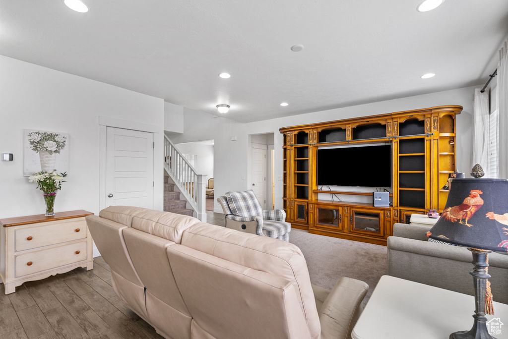 Living room with stairs, recessed lighting, and wood finished floors