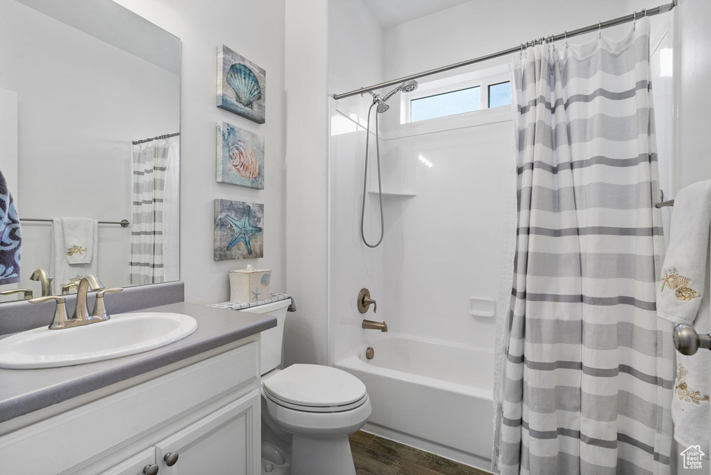 Full bathroom featuring vanity, wood finished floors, and shower / bath combo