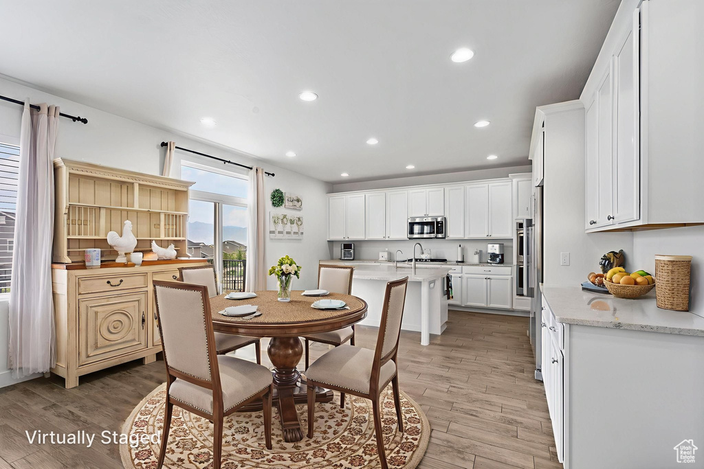 Dining area with light wood-type flooring and recessed lighting