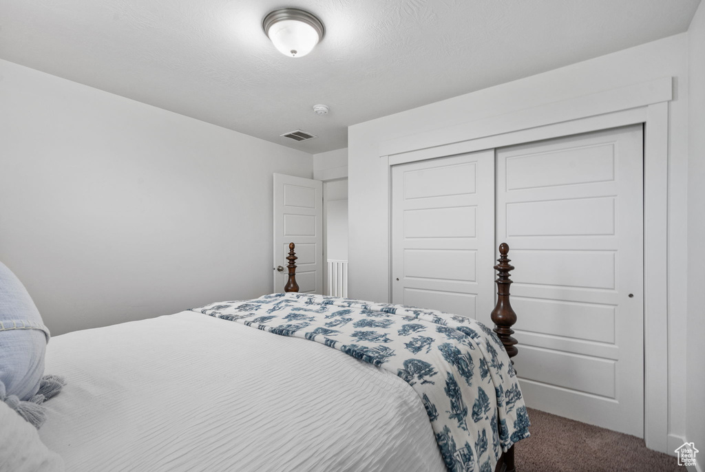 Bedroom featuring dark carpet and a closet