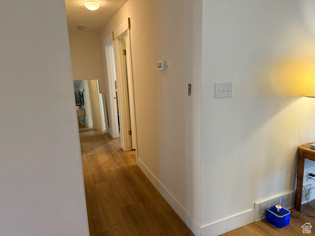 Hall with wood finished floors and baseboards