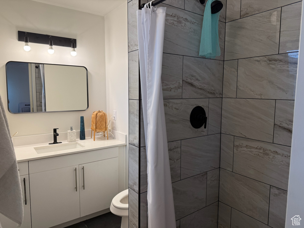 Full bath featuring vanity and tiled shower