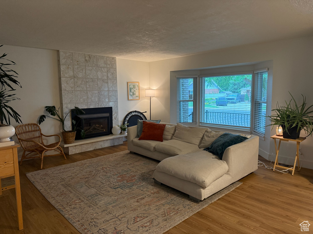 Living area with wood finished floors, a fireplace, and a textured ceiling