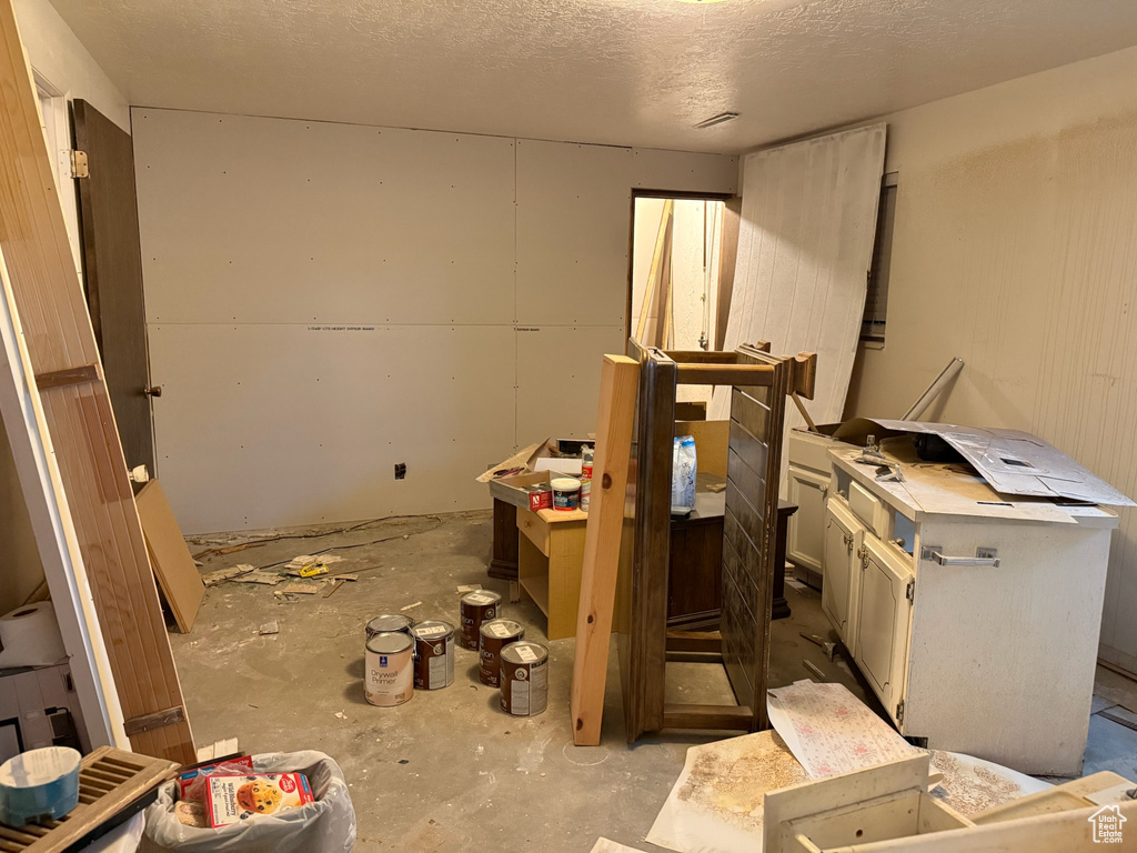 Misc room featuring concrete flooring and a textured ceiling