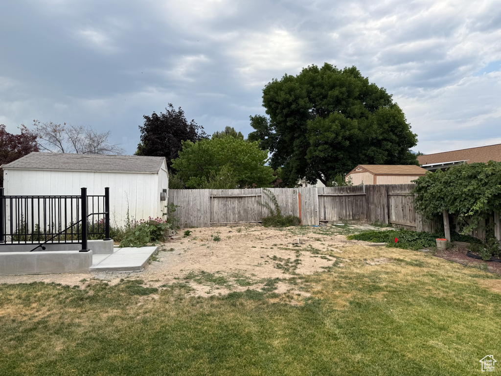 Fenced backyard featuring an outdoor structure