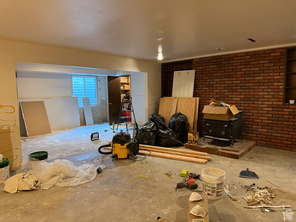 Living area featuring a wood stove and brick wall