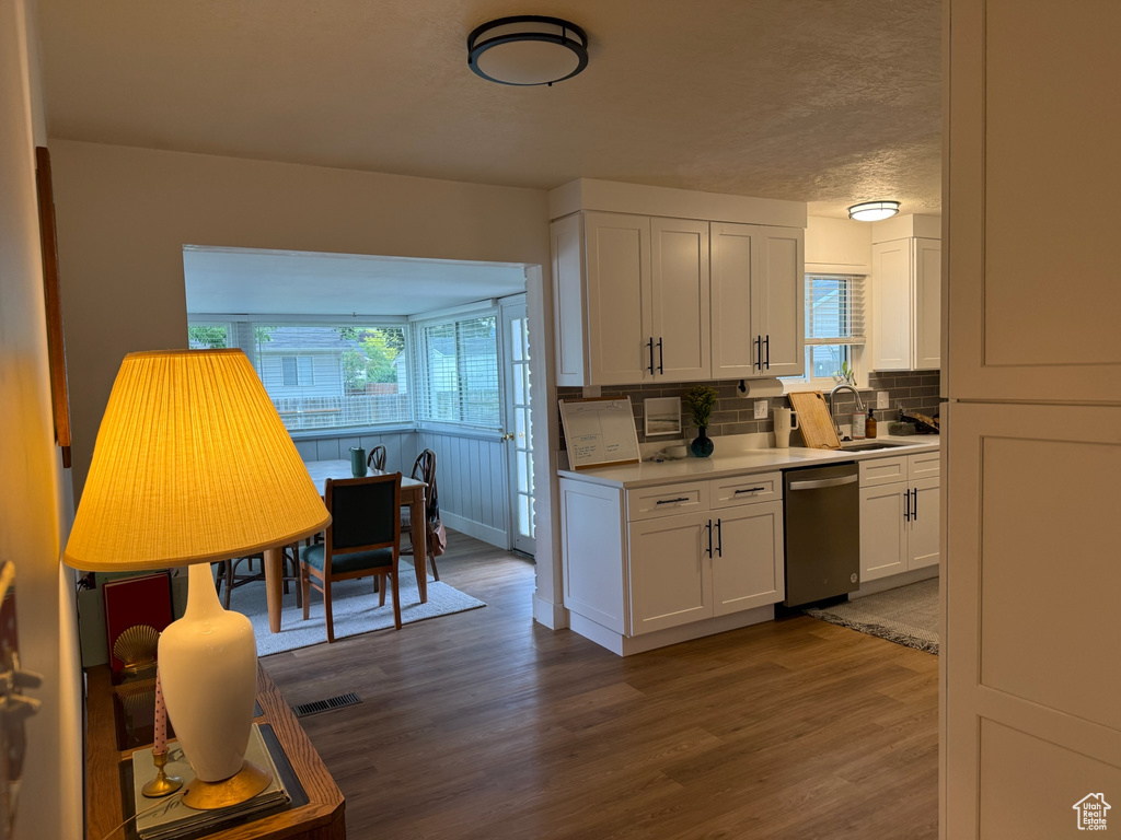 Kitchen featuring dark wood finished floors, white cabinetry, tasteful backsplash, light countertops, and a textured ceiling