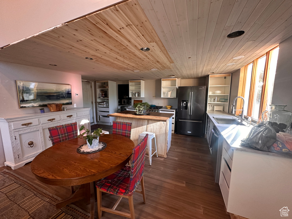 Dining room with dark wood-style flooring and wood ceiling