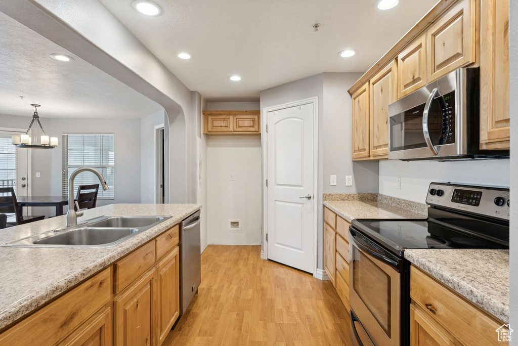 Kitchen featuring appliances with stainless steel finishes, light wood-style flooring, light brown cabinetry, light countertops, and recessed lighting