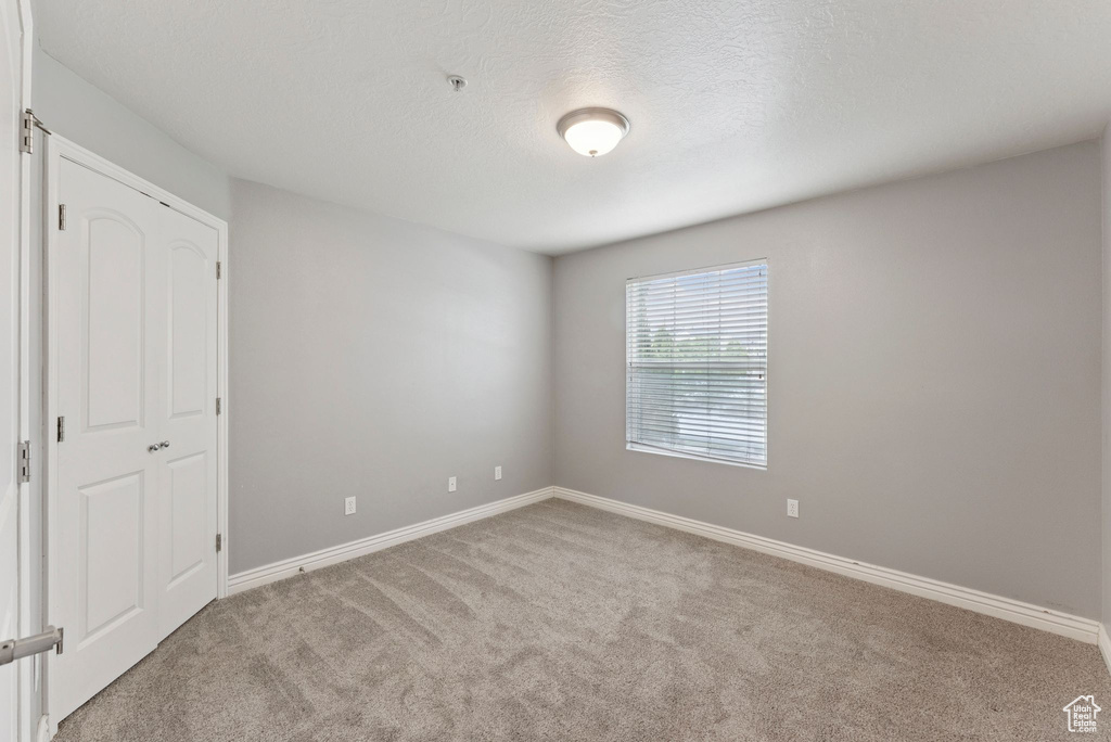 Unfurnished bedroom featuring carpet flooring and a textured ceiling