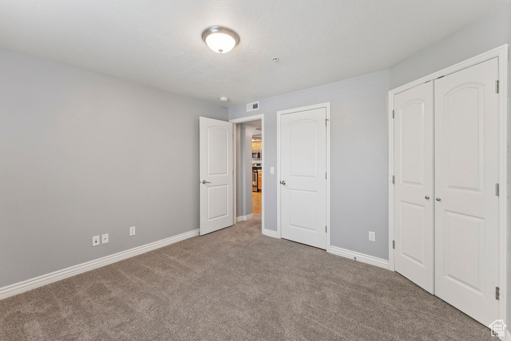 Unfurnished bedroom with carpet floors and a closet