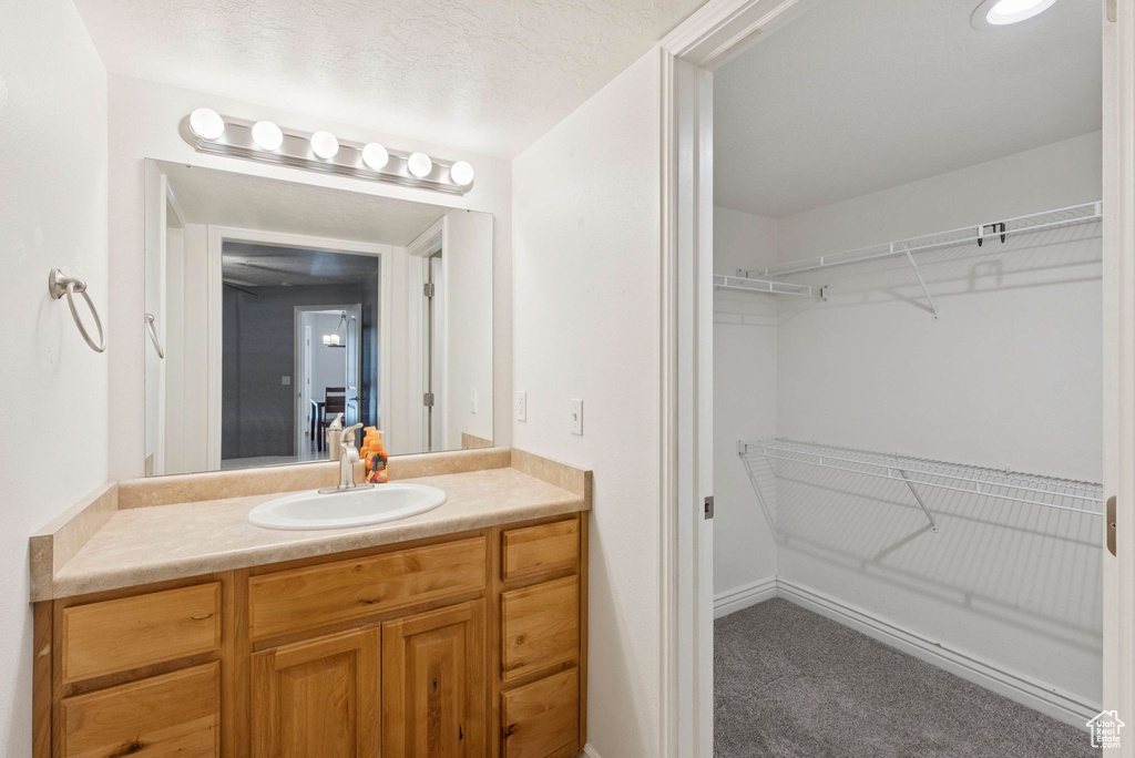 Bathroom with vanity and a spacious closet