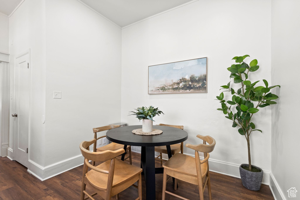 Dining area featuring crown molding and dark wood finished floors