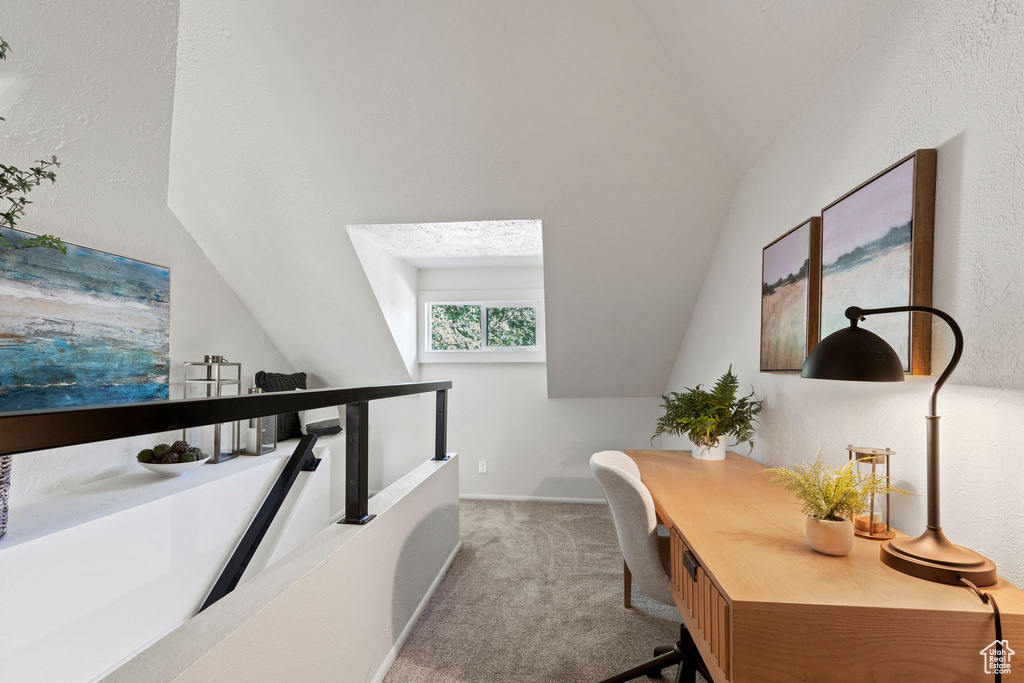 Carpeted office space with lofted ceiling