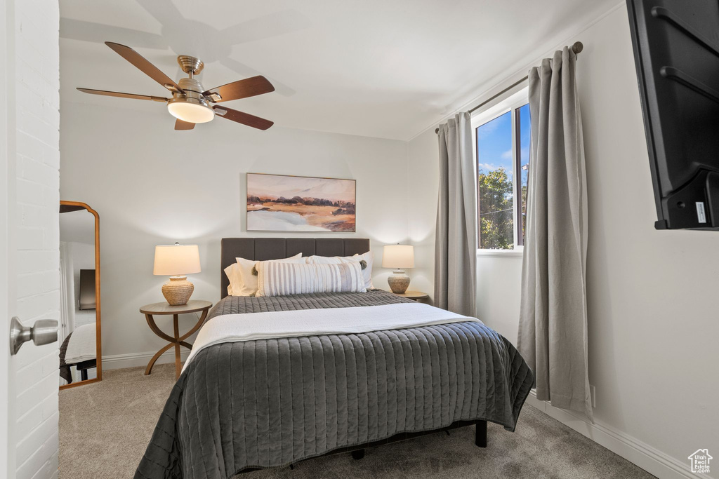 Carpeted bedroom featuring baseboards and a ceiling fan