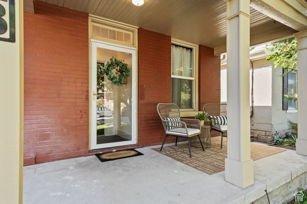 Property entrance featuring a porch and brick siding