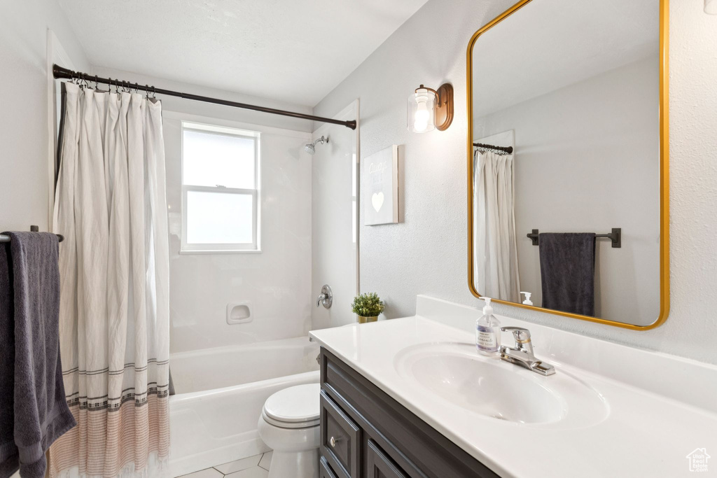 Full bathroom featuring vanity, shower / tub combo with curtain, and tile patterned flooring