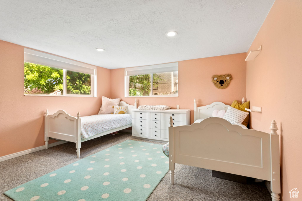 Carpeted bedroom with a textured ceiling and recessed lighting