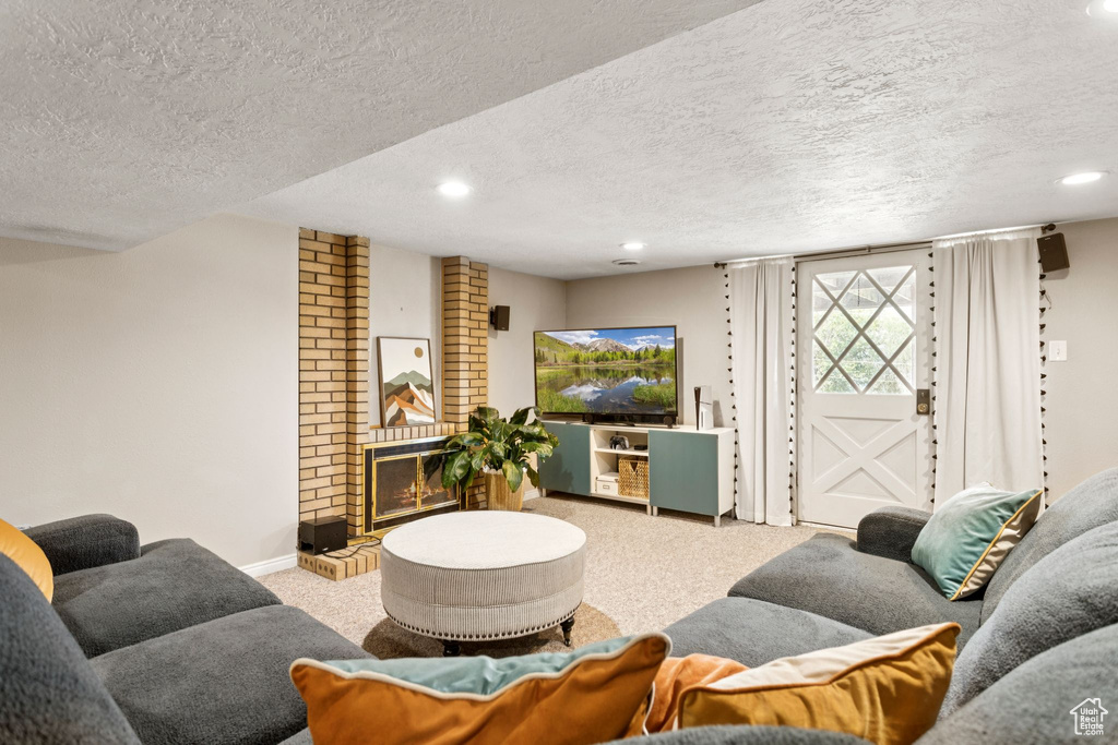 Living room featuring carpet flooring, recessed lighting, a textured ceiling, and a fireplace