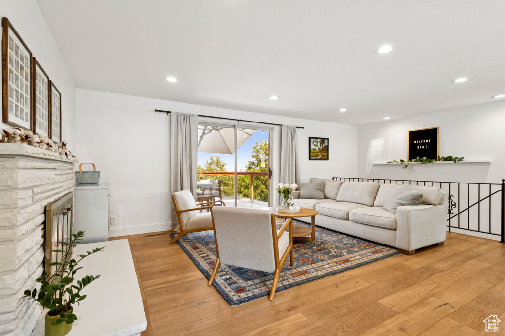 Living area featuring light wood-type flooring, recessed lighting, and a stone fireplace