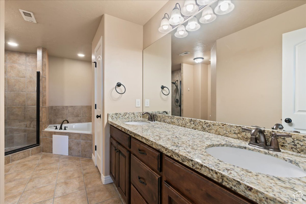 Full bath with a bath, double vanity, tile patterned floors, and tiled shower