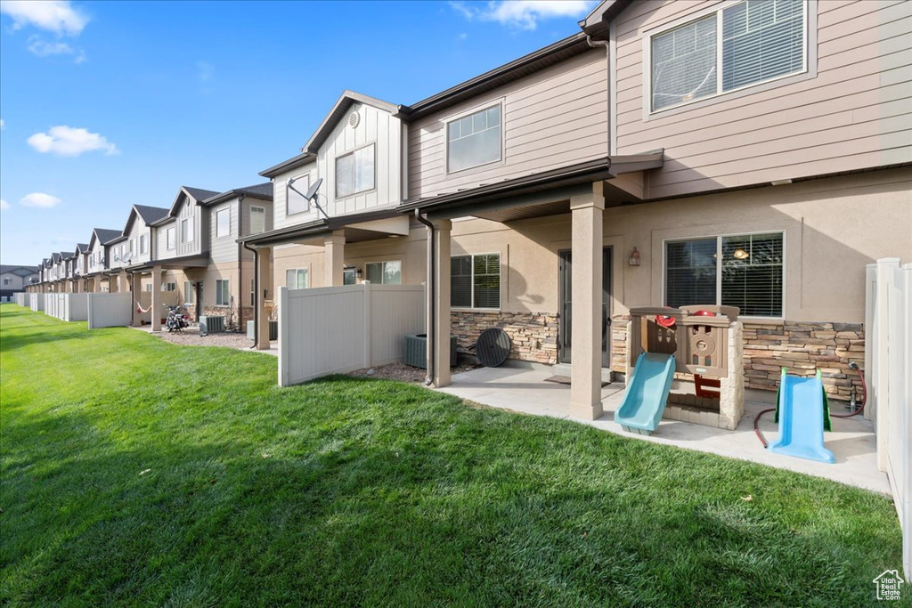 Rear view of property with stone siding, a residential view, a patio, and board and batten siding