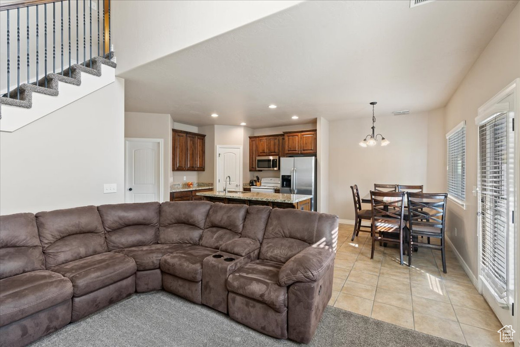 Living room with recessed lighting, light tile patterned floors, and a chandelier
