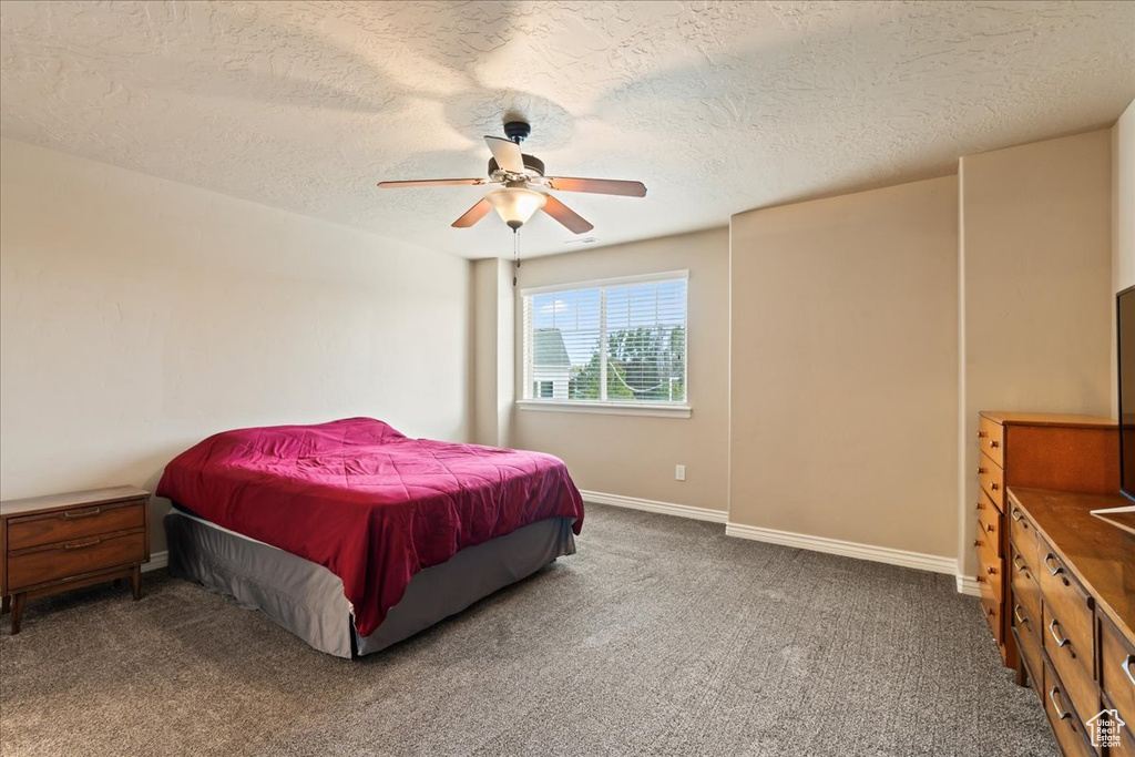 Bedroom with carpet, a textured ceiling, and ceiling fan