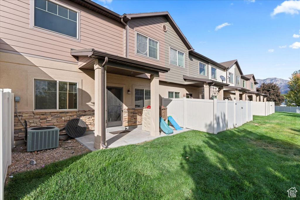 Back of property with a patio, a mountain view, and stone siding