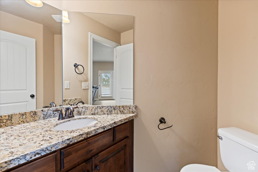 Half bathroom with toilet and vanity