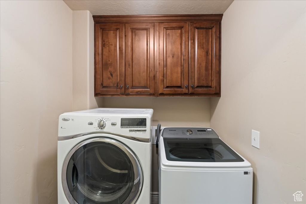 Laundry area featuring cabinet space and independent washer and dryer