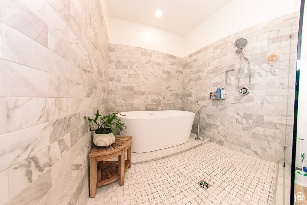 Bathroom featuring a soaking tub, tile walls, a tile shower, and recessed lighting
