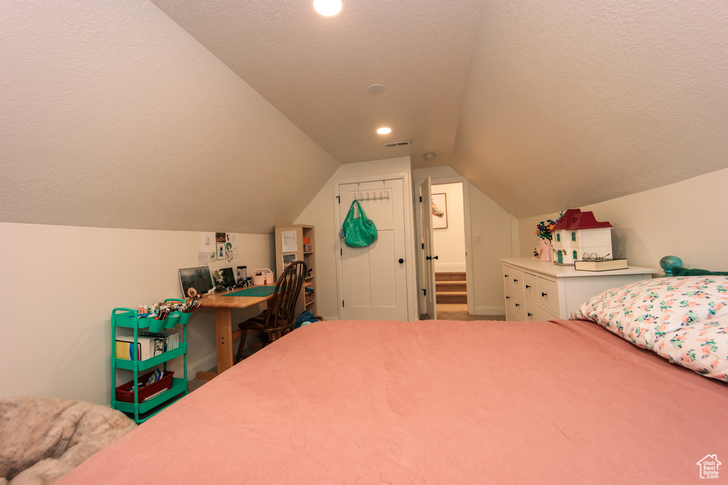 Bedroom featuring vaulted ceiling, a textured ceiling, and recessed lighting